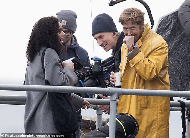 The Barbie actress braved the elements in a yellow raincoat for the stormy seaside scenes.