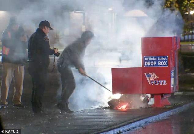 Authorities seen working to put out a fire at an urn in Vancouver, WA began early Monday morning. It was one of two fires set at two ballot boxes in two different states.