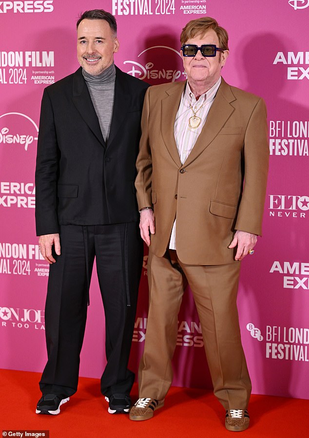 The musician was supported by her husband David Furnish (pictured) and godson Damian Hurley as they graced the Royal Festival Hall red carpet.