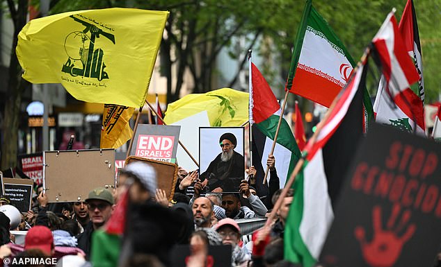 Melbourne protesters were seen holding up framed photographs of recently assassinated Hezbollah chief Hassan Nasrallah (pictured center) and yellow and green Hezbollah flags (pictured left).