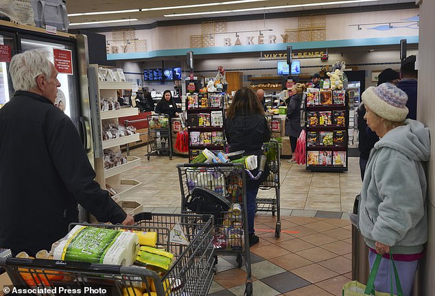 Shoppers line up to buy groceries at a Gelson supermarket on Friday, March 20, 2020, in the Sherman Oaks section of Los Angeles.