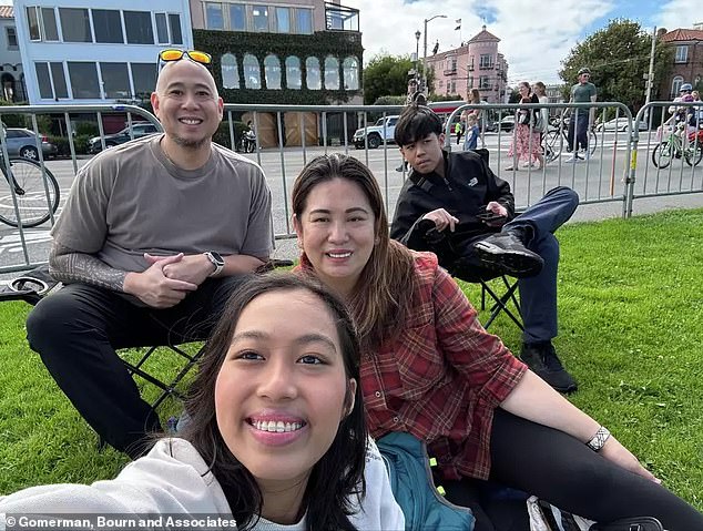 Millicent 'Mia' DeGuzman, center, takes a selfie with her family