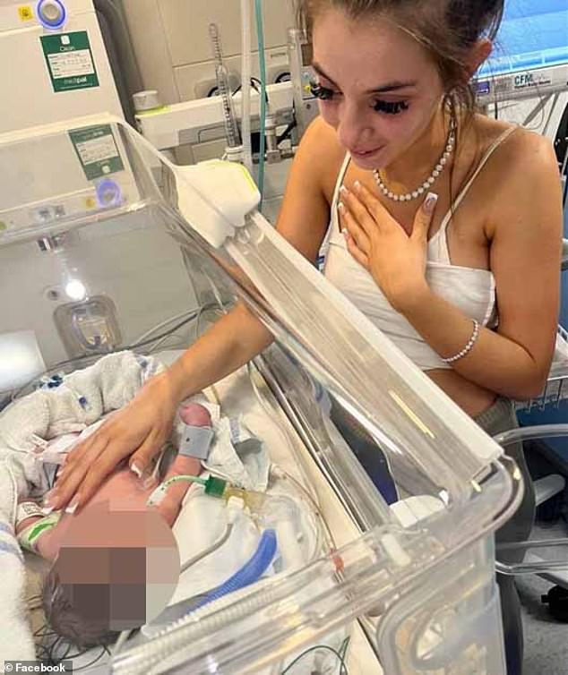 Little Posie is seen in her hospital crib with tubes in her mouth and nose while her sister Demi lovingly places her hand on her chest.