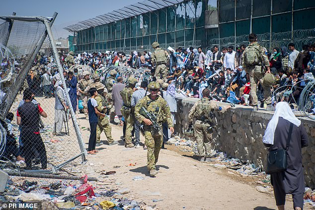 Soldiers help Afghans evacuate the country in August 2021, as the Taliban rampaged through province after province, taking control.