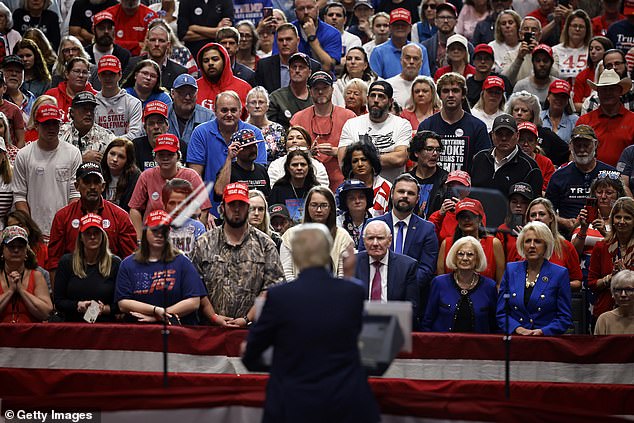 Fans look at Trump during his rally.