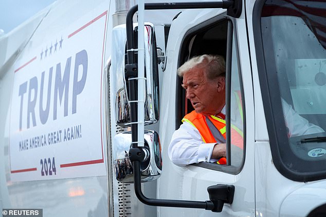 Republican presidential candidate and former US President Donald Trump sits inside a garbage truck while wearing a high-visibility vest, on the tarmac at Green Bay Austin Straubel International Airport in Green Bay, Wisconsin, on Wednesday.