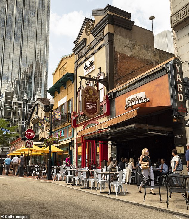 The Steel City isn't just about heavy industry anymore: it's also a hotspot for sports and sandwiches, and now for savvy house hunters looking to get more bang for their buck (pictured: people walking through the restaurants and shops in Market Square in downtown)