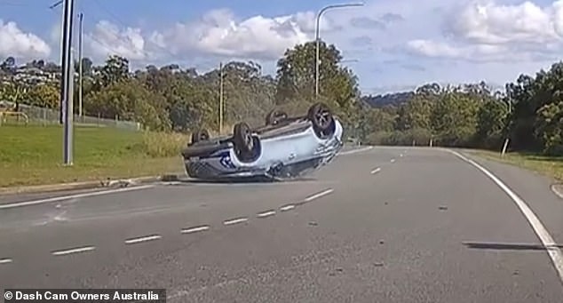 The collision sent the car flying through the air before coming to rest upside down (pictured) and resulted in a passenger having to be taken to hospital with a minor neck injury.