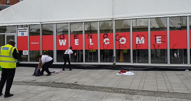 Two Youth Demand supporters appear spray painting the words 