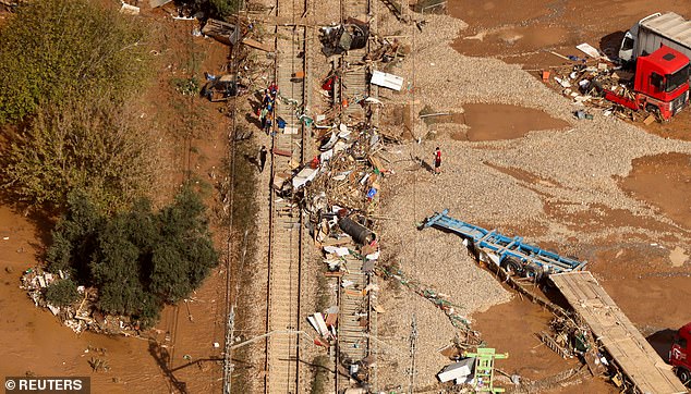 Debris scattered across a train track after flooding in the Valencia region