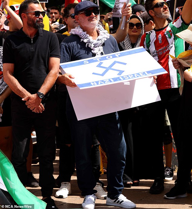 Al Yazbek pictured holding the Nazi swastika superimposed on an Israeli flag at a protest in Hyde Park in Sydney's central business district.