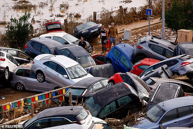 People stand next to stranded cars after flooding in Valencia, Spain, on October 31, 2024.