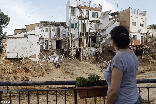 A woman looks at a mud-covered road and damaged houses in the flood-affected municipality of Chiva, near Valencia, Spain, on October 31, 2024.