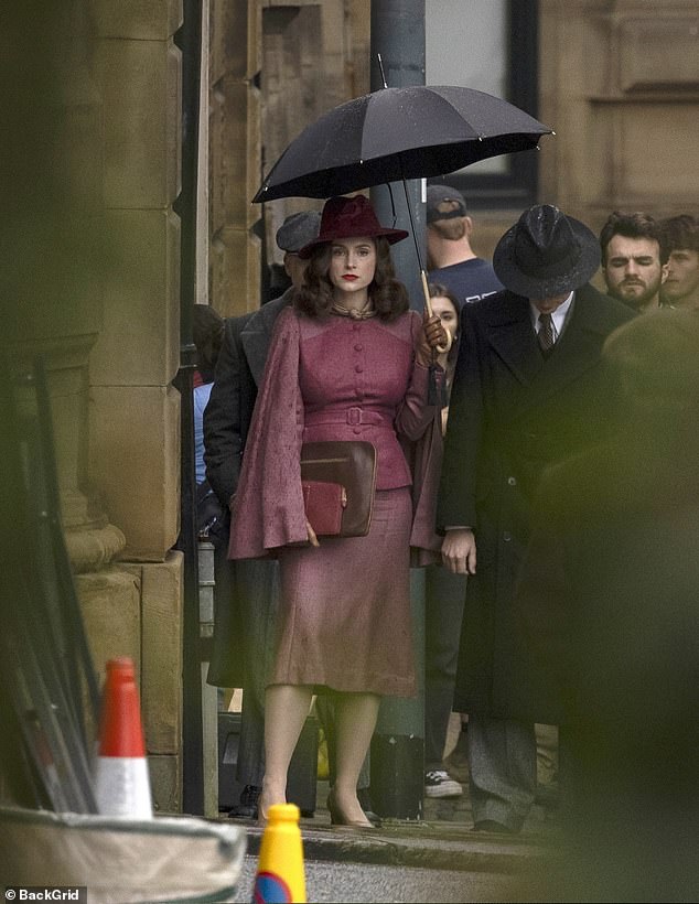 Sophie held an umbrella as she sheltered from the rain.