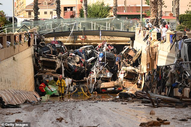 Members of the fire brigade, who are part of a search and rescue unit, carry out work as cars and debris block a tunnel after the recent flash flood in the nearby municipality of Benetusser on November 1.