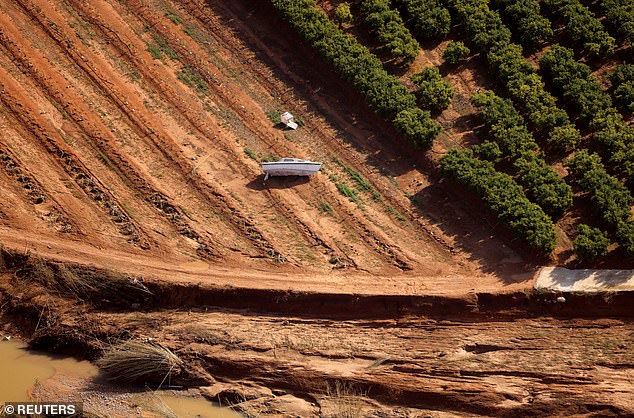 A boat is stranded in a field after flash floods in the Valencian Community