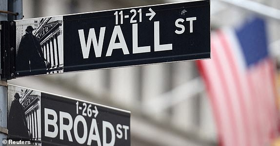 FILE PHOTO: A Wall Street sign hangs in front of an American flag outside the New York Stock Exchange (NYSE) ahead of the Federal Reserve announcement in New York City, US, on September 18 2024. REUTERS/Andrew Kelly/File Photo