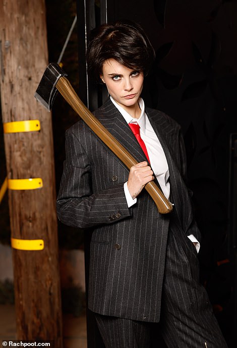 Model Cara, 32, carried an ax and wore a suit as she transformed into Christian Bale from American Psycho while giving a terrifying look at the camera.