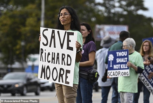 Protesters watch before the scheduled execution of Richard Moore, Friday, Nov. 1, 2024, outside the prison.