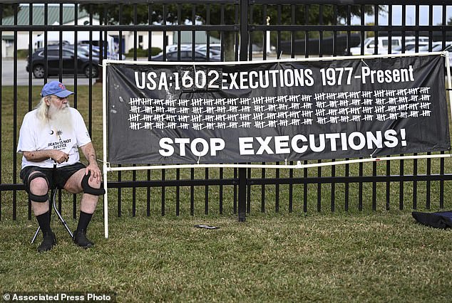 A protester watches before the planned execution of Richard Moore.