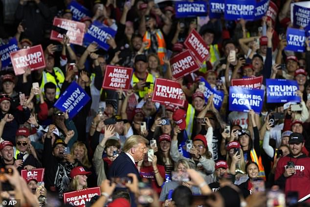 Fans wave chants as Trump enters the arena. Many fans wore neon vests.