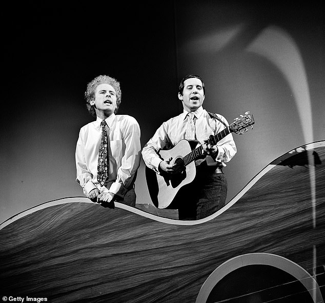 Simon and Garfunkel sing and play guitar while performing on the CBS variety show 'The Red Skelton Hour' in 1966.