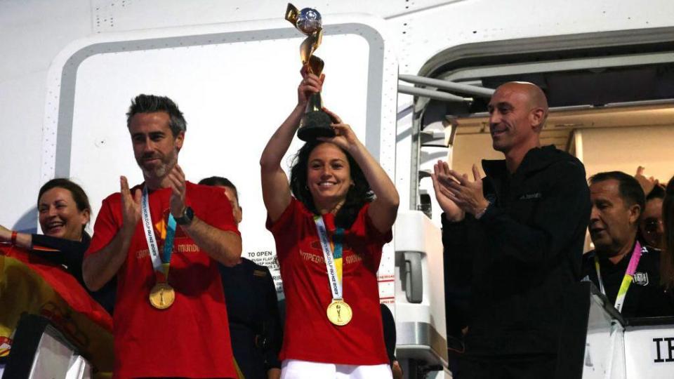 Spanish footballer Ivana Andrés holds the World Cup trophy alongside Spanish coach Jorge Vilda (left) and the president of the Spanish football federation, Luis Rubiales (right)