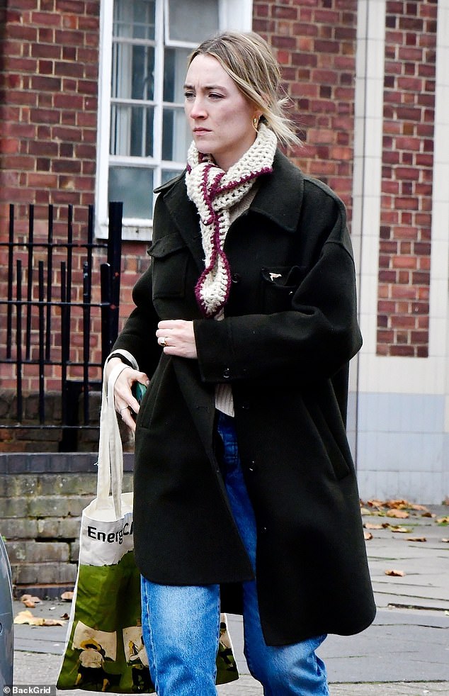 The star completed her look with a chunky knit scarf, gold hoop earrings and gold rings.