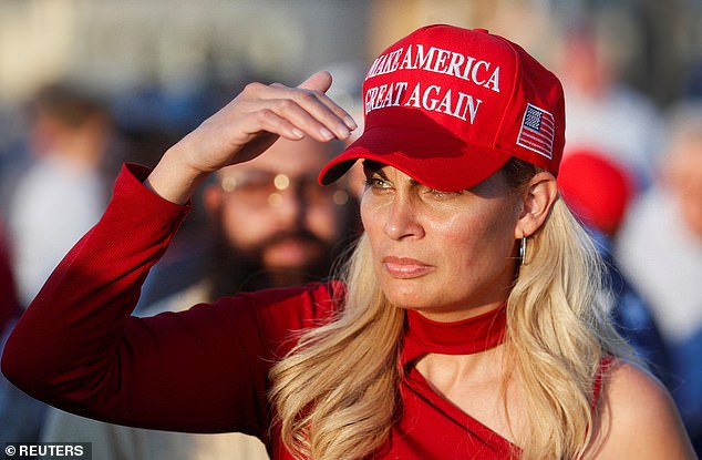 A supporter of Republican presidential candidate and former US President Donald Trump looks on wearing a MAGA hat.