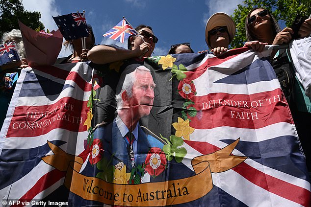 Australians waving union flags with King Charles as they wait to greet the monarch and Queen Camilla in Sydney on October 20.