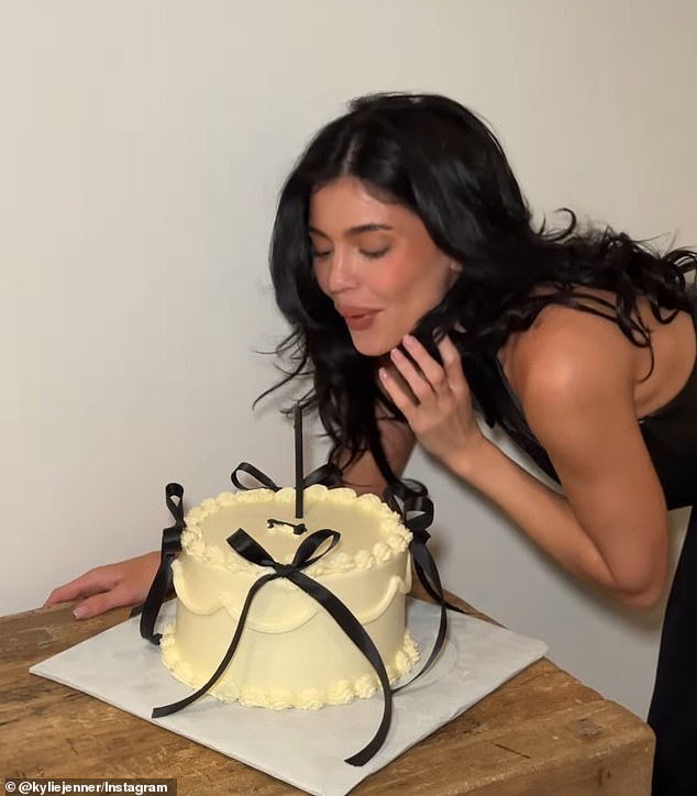 For the milestone, the Kylie Cosmetics founder celebrated with a yellow cake and a candle, while wearing a black leather ensemble that appeared to include a halter top and skirt combo.