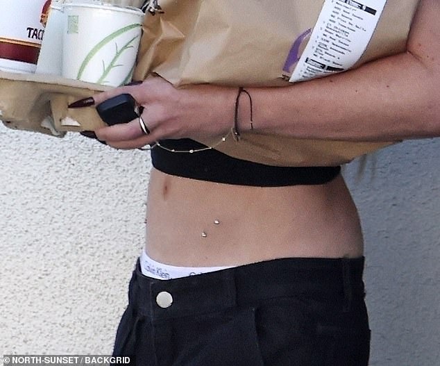 The former Beverly Hills, 90210 star, 51, revealed her flat stomach, adorned with a set of dermal piercings.