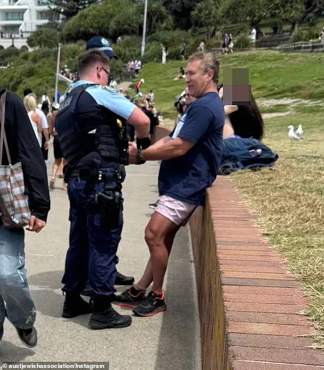 The man, who has not yet been formally identified, was confronted by police in Sydney's Bondi Beach for wearing the T-shirt 