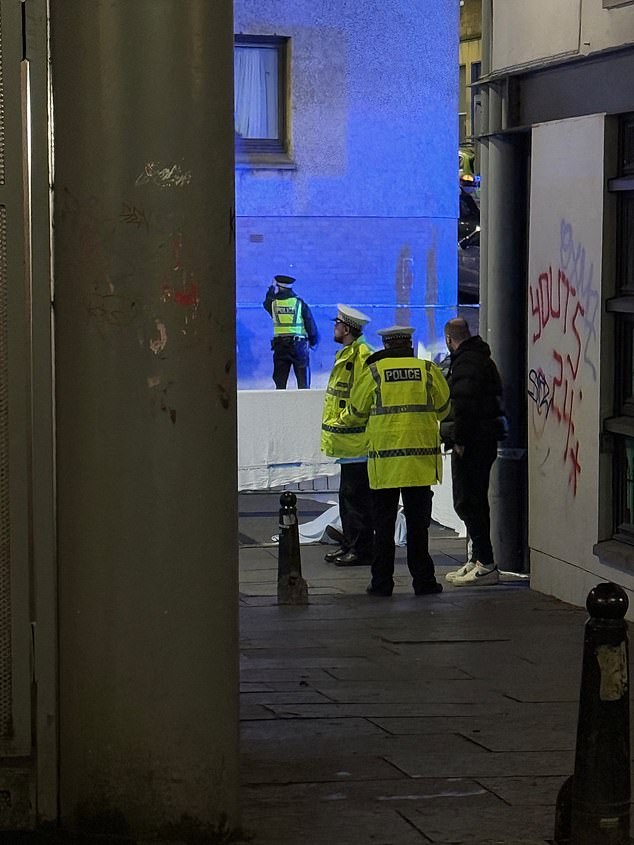 An image captured by witnesses shows police officers standing next to the scene that has been recorded with tape.