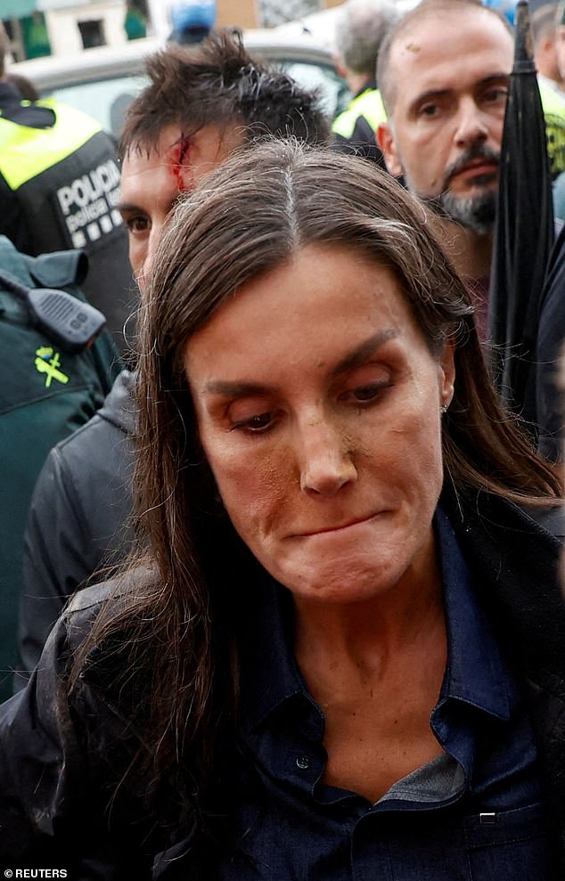 The hecklers targeted Letizia, as footage shows the Queen with mud on her face as they helped her walk through the busy streets.