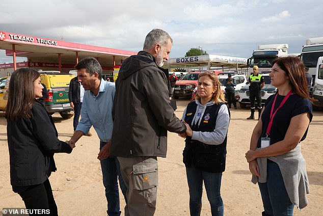 King Felipe and Queen Letizia of Spain shake hands with authorities and emergency service personnel outside a command center as they visit areas affected by DANA, following heavy rain that caused flooding, in Paiporta, near Valencia, Spain, on November 3, 2024.