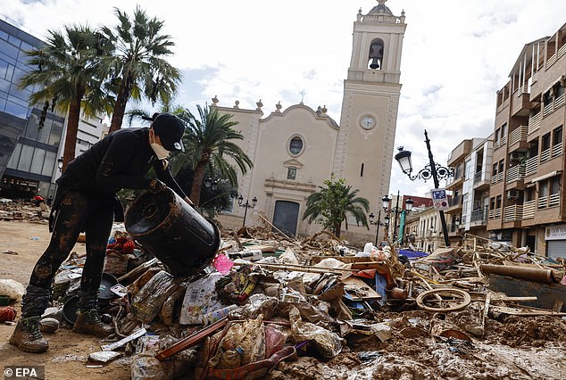 A volunteer cleans a square after the floods in Paiporta, a town especially affected by the floods