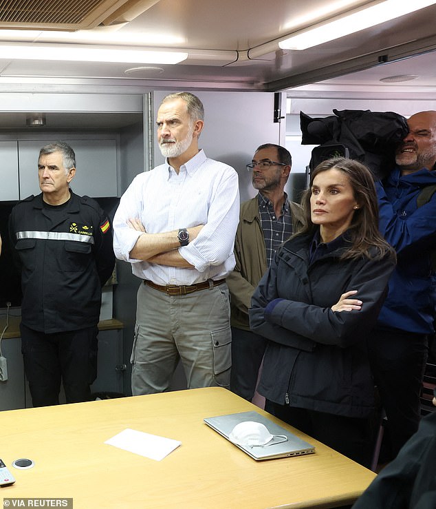 King Felipe and Queen Letizia observe with emergency services personnel in a command center