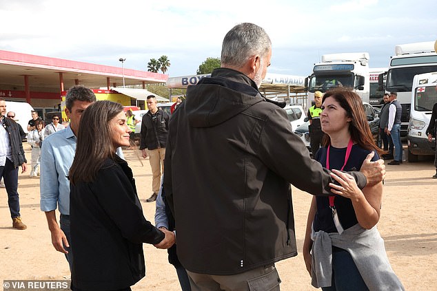 Queen Letizia and King Felipe speak with authorities and emergency services personnel