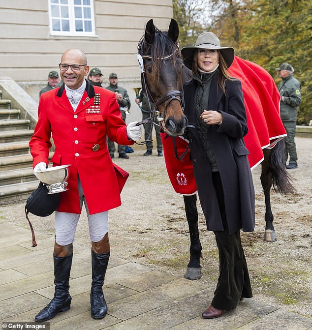 Queen Mary of Denmark poses with the winner of the Hubertus hunt