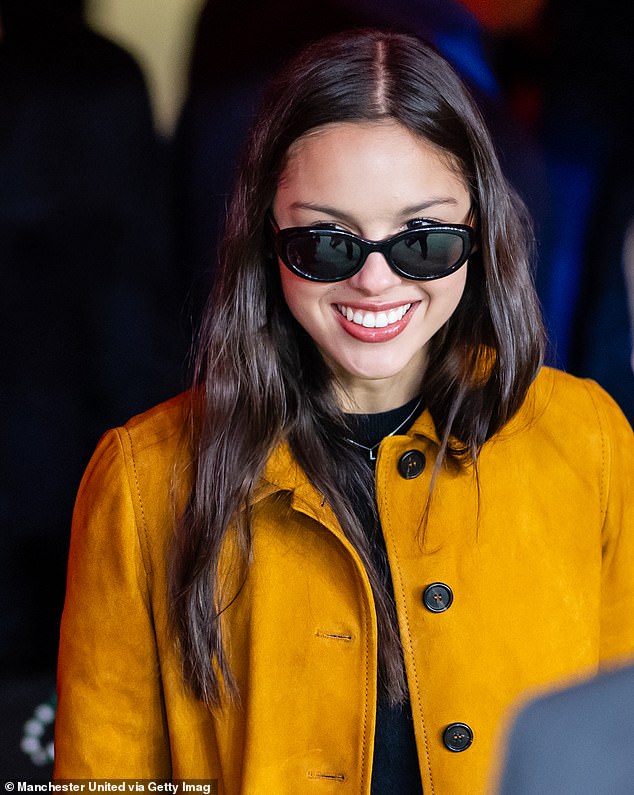 The American pop icon made a stylish appearance in a mustard jacket and polka dot mini skirt as she descended onto the pitch at the Old Trafford stadium in Manchester.