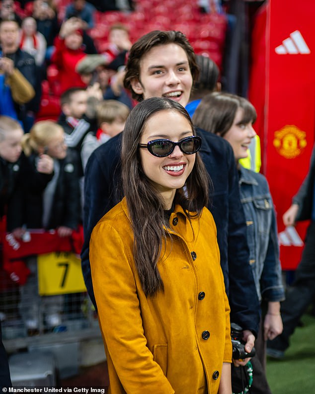 Her boyfriend Louis Partridge joined her as the couple watched the grueling warm-up before the big match.