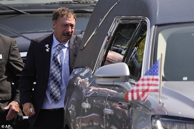 Guy Gaudreau, the father of the deceased brothers, watches the hearse drive away after his son's service on September 9.