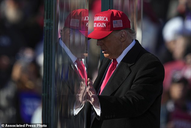 Republican presidential candidate former President Donald Trump is reflected in the bulletproof glass as he finishes speaking at a campaign rally in Lititz, Pennsylvania, on Sunday.