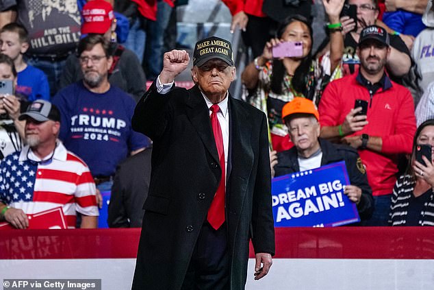 Trump raises his fist after speaking at the end of a campaign rally in Macon, Georgia, on Sunday night.