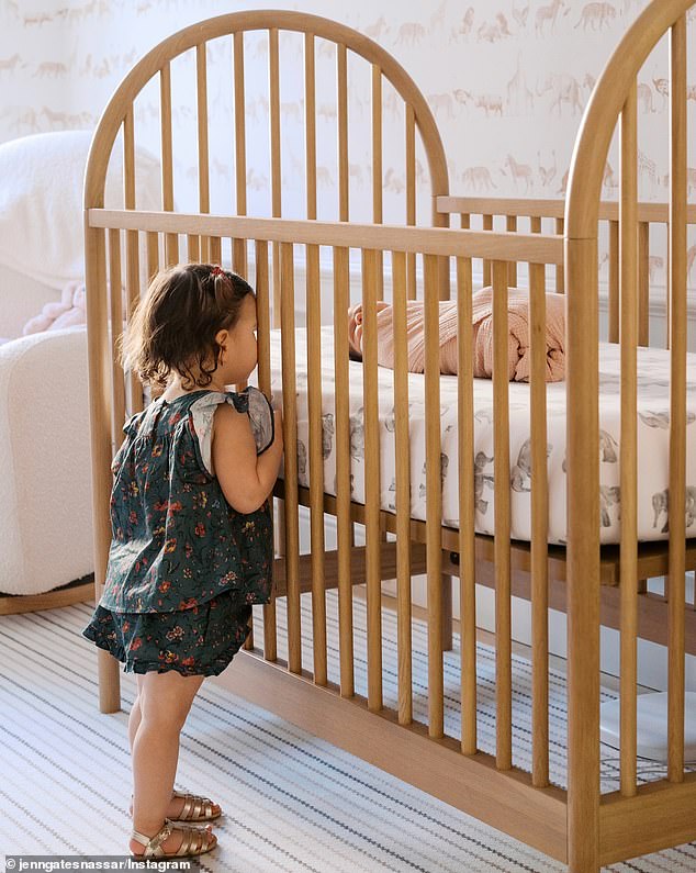 Jennifer shared a photo of her first daughter, Leila, keeping an eye on the newborn through the slats of her crib.