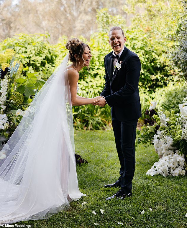 The genetically blessed couple laughed in a picturesque setting.