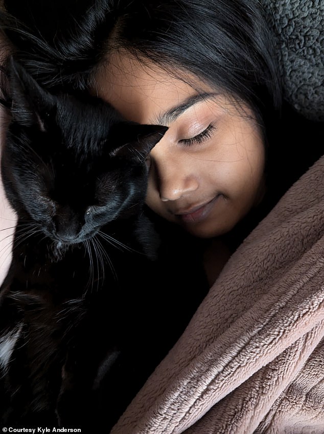 Anderson's fiancée, Vidhi, with one of their seven cats, named Beelzebub.