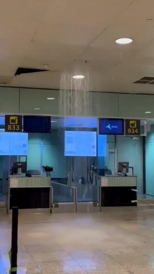 Water is seen coming from the roof of El Prat airport, where flights have been diverted by the deluge