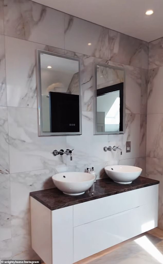 Mark also took fans on a tour of another smaller bathroom in the grand home, which this time featured gray marble tiles, as well as his and her sinks and a luxurious freestanding bathtub.